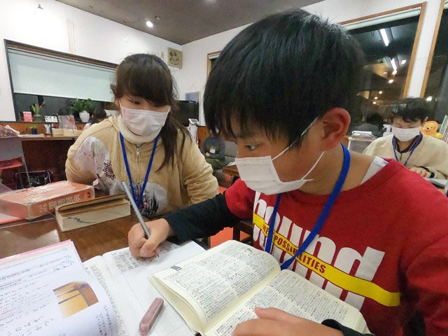 大学生に教えてもらう小学生＝岐阜市高河原、喫茶店「カフェマム」
