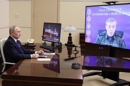　２６日、モスクワでモニターを通じてロシア軍のゲラシモフ参謀総長から戦況の報告を受けるプーチン大統領（スプートニク提供・ＡＰ＝共同）