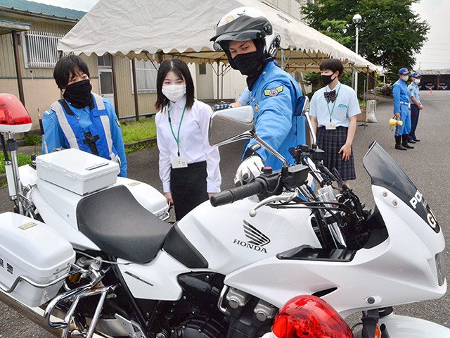 交通警察官から白バイについて説明を受けるセミナーの参加者＝瑞穂市牛牧、県警交通機動隊