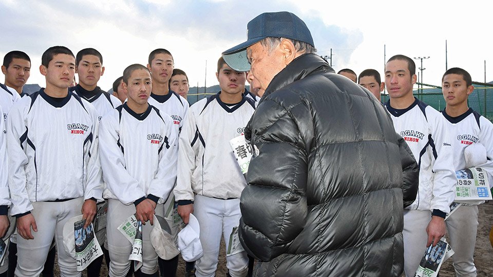 選抜高校野球大会出場が決まり、阪口慶三監督（手前）の話を聞く大垣日大の選手たち＝２８日午後４時１２分、安八郡神戸町末守、大垣日大高校野球部グラウンド