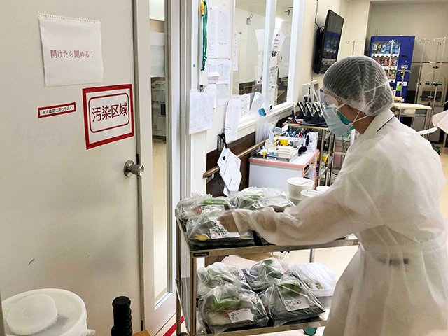 汚染区域のレッドゾーンへ食事の配膳に向かうフル装備の看護師＝２６日午後６時１３分、岐阜市橋本町、朝日大病院（同病院提供）