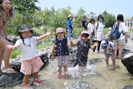 　里山を再現した屋外の新エリア「わくわく・はじまりの森」で川遊びをする子どもたち＝８日午前、福島県いわき市の水族館アクアマリンふくしま