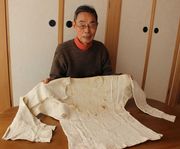 過去には博物館の特別展で公開されたこともあるという「血染めのシャツ」について語る村雨耕一さん＝愛知県安城市