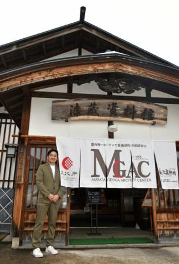 　漫画の原画を収蔵するため改修された元地主の屋敷と、「横手市増田まんが美術館」の大石卓館長＝５月、秋田県横手市