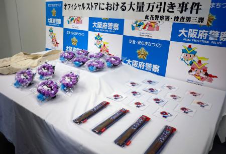 　押収された扇子（右下）などの大阪・関西万博公式グッズ＝１３日午後、大阪府警本部