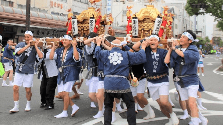 水を掛けられながら勢いよくみこしを旋回させる担ぎ手ら＝大垣市東外側町、大垣駅通り