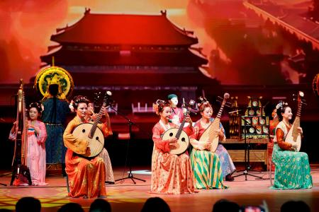 　中国ナショナルデーで披露された伝統的な衣装を身にまとった女性による演奏＝１１日午前、大阪市此花区の夢洲（代表撮影）