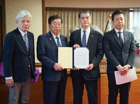 　再審制度の早期見直しを求め、平口法相（左から２人目）に要望書を手渡す超党派の国会議員連盟メンバー＝１４日午後、法務省