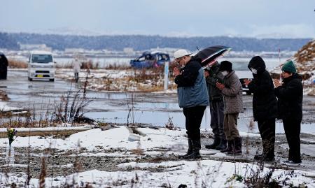 　能登半島地震の発生時刻に手を合わせる人たち＝１日午後４時１０分、石川県珠洲市宝立町