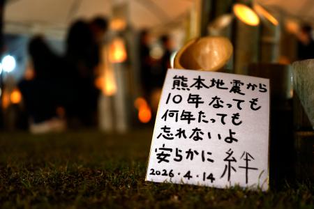 　熊本地震の「前震」から１０年となり、犠牲者を悼みともされた竹灯籠のそばに置かれたメッセージ＝１４日夜、熊本県益城町