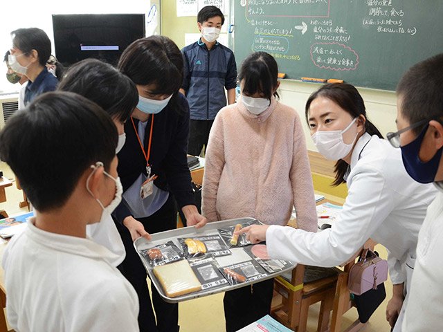 医師の勅使河原志保さん（右から２人目）から食品に含まれる塩分量について教わる児童＝中津川市阿木、阿木小学校