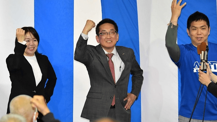 当選を確実とし、力強く拳を握る浅野健司氏（中央）＝各務原市那加不動丘、選挙事務所前