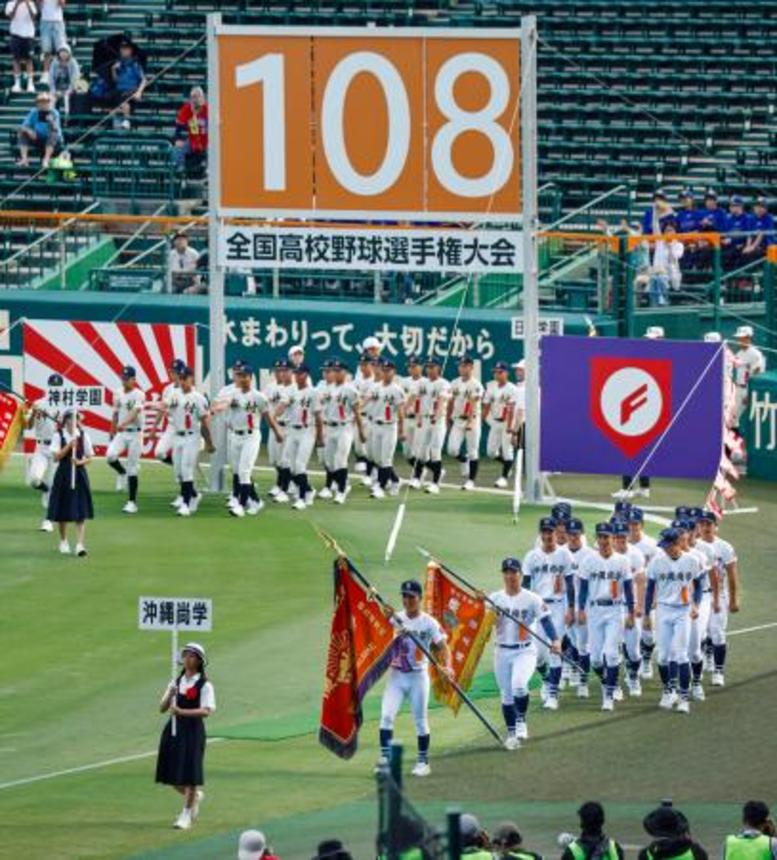 　第１０８回全国高校野球選手権大会の開会式で入場行進する沖縄尚学（手前）の選手ら。厳しい暑さへの対策として夕方から実施された＝５日、甲子園球場