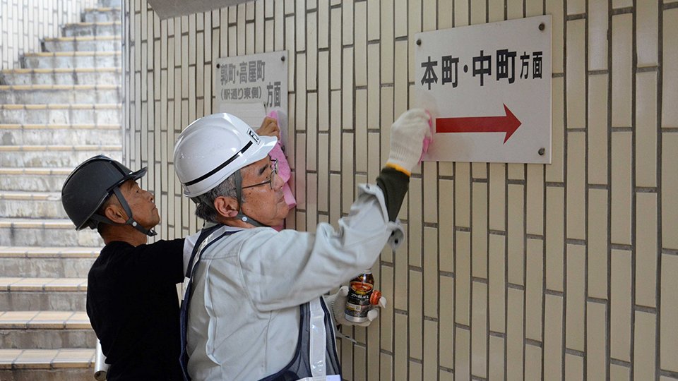 溶剤を使って地下歩道の落書きを消す西濃部会メンバー＝大垣市郭町、大垣駅通り