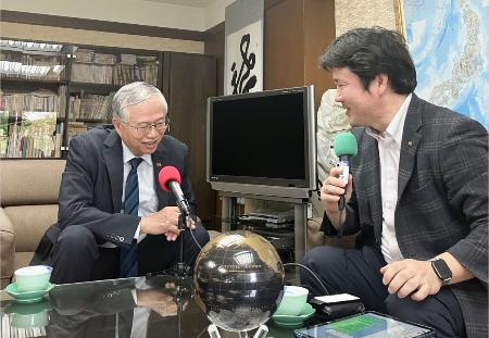 　台北駐日経済文化代表処の蔡明耀副代表（左）にインタビューする和田健一郎さん＝４月、東京都港区（和田さん提供）