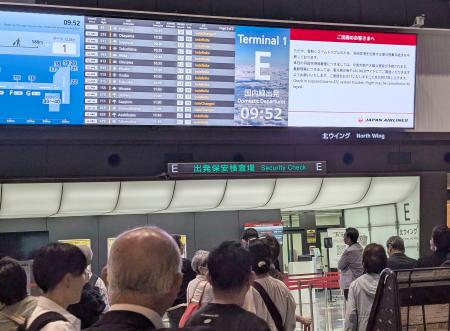 　管制トラブルによる遅延などを伝える羽田空港内の電光掲示板＝２１日午前９時５３分