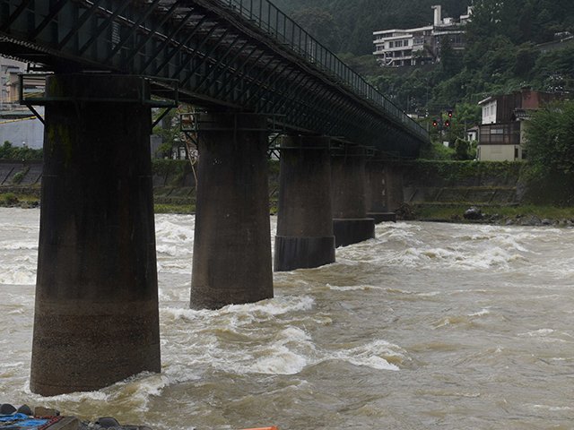 鉄橋の橋脚で波を立てる飛騨川＝１７日午前、岐阜県下呂市湯之島