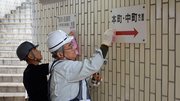 溶剤を使って地下歩道の落書きを消す西濃部会メンバー＝大垣市郭町、大垣駅通り