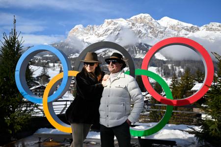 　イタリア・コルティナダンペッツォで五輪マークと写真に納まる人たち＝６日（共同）