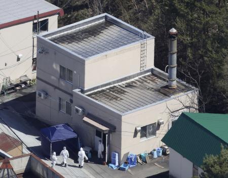 　旭山動物園の現場検証で、焼却炉がある建物に入る捜査員ら＝４月２５日