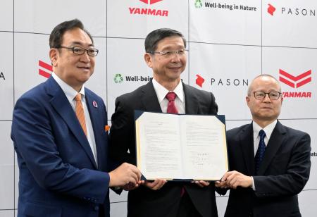 　連携協定を結び、記念撮影するヤンマーＨＤの山本哲也ＣＯＯ（中央）ら＝２２日午前、大阪市北区