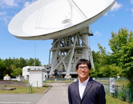 　電波望遠鏡の前に立つ国立天文台野辺山宇宙電波観測所の西村淳所長＝６月、長野県南牧村