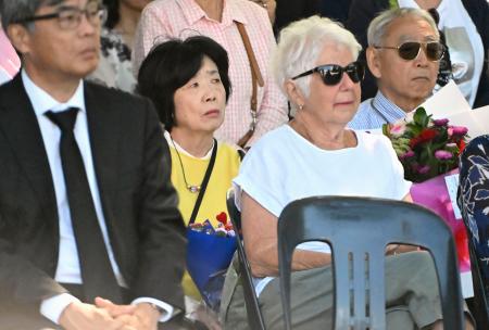 　２２日、ニュージーランドのクライストチャーチで開かれた地震の追悼式に出席した堀田めぐみさんの両親（奥）ら（共同）