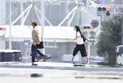 猛暑で逃げ水現象の現れた道路を渡る人＝２１日午後１時４０分、岐阜市神田町（撮影・堀尚人）