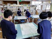 鵜沼第一小学校から送られた古里紹介の新聞を読む蕨島小児童＝２０２１年３月、鹿児島県出水市荘、蕨島小学校