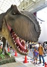 巨大なティラノサウルスを前に歓声を上げる家族連れ＝岐阜市柳ヶ瀬通