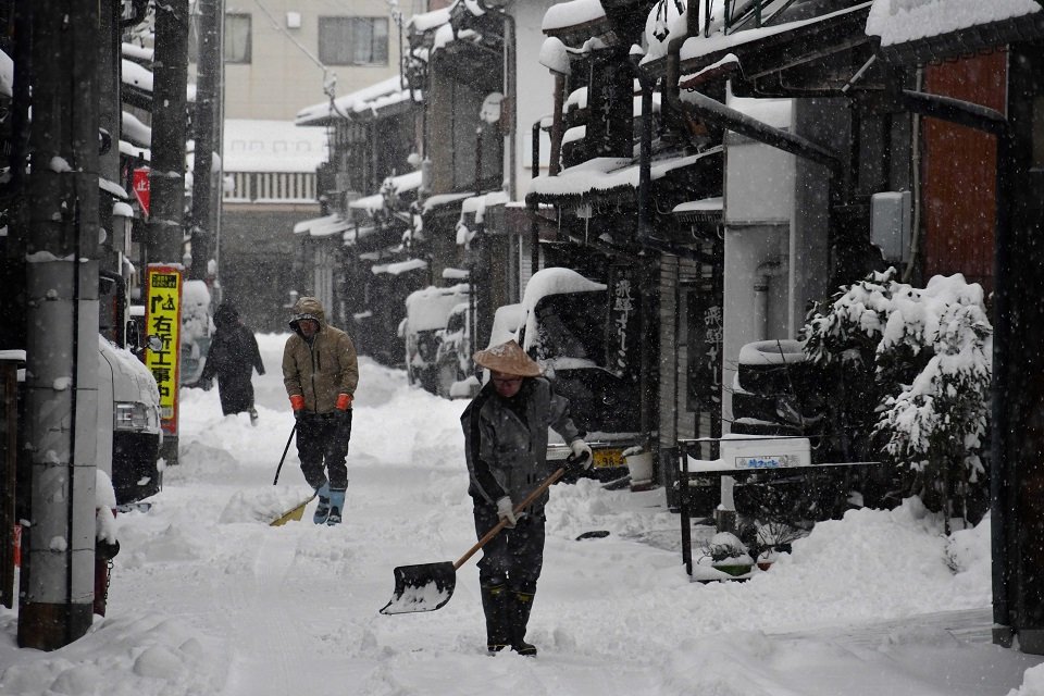 雪かきに追われる住民＝２５日午前７時３３分、高山市片原町