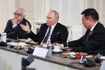 　１８日深夜、ロシア北西部サンクトペテルブルクで各国通信社の代表らと会見に臨むプーチン大統領（中央）（タス＝共同）