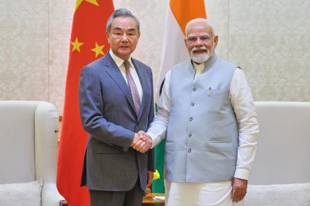 　１９日、ニューデリーで握手するインドのモディ首相（右）と中国の王毅外相（インド首相府提供・ＡＰ＝共同）
