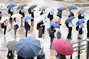 雨の中、傘を差してバスを待つ人たち＝２日午前７時４９分、岐阜市橋本町、ＪＲ岐阜駅北口