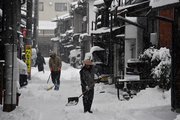 雪かきに追われる住民＝２５日午前７時３３分、高山市片原町
