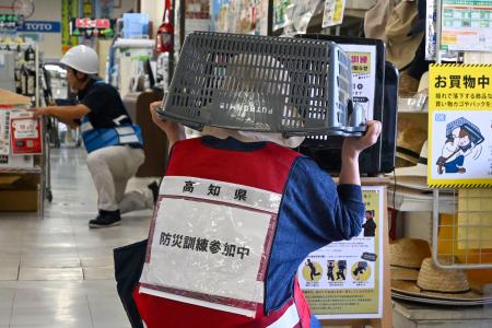 　「シェイクアウト訓練」を行う参加者＝３１日午後、高知県須崎市