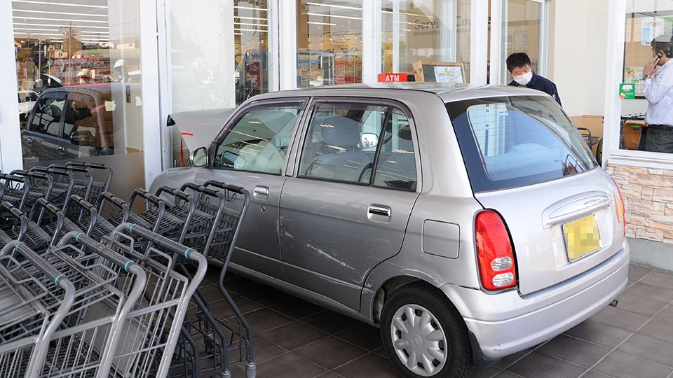 店舗に突っ込んだ軽乗用車＝１３日午後３時４０分、可児市下恵土、バロー下恵土店