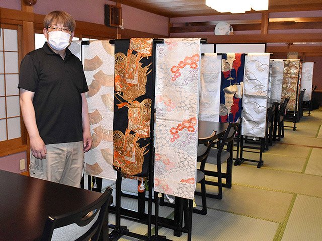 コロナ対策のパーティションで着物の帯を設置した佐竹新司社長＝養老町飯田、養老魚新