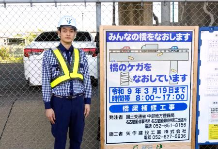 　設置された工事看板と考案者の杉山領人さん＝６日、名古屋市