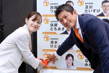 　東京選挙区で当選を決めたさや氏（左）と花を付ける参政党の神谷代表＝２０日午後９時１１分、東京都新宿区