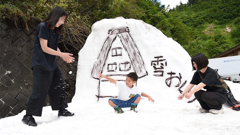 夏空の下、雪遊びを楽しむ親子＝１３日、大野郡白川村飯島、白山白川郷ホワイトロード三方岩駐車場