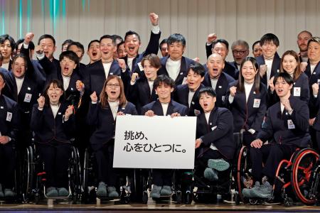 　ミラノ・コルティナ冬季パラリンピック日本選手団の結団式で、スローガン「挑め、心をひとつに。」を掲げ写真に納まる選手たち＝１２日午後、東京都内