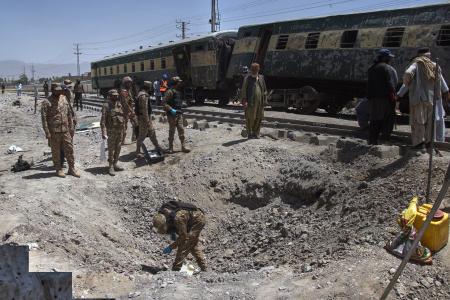 　パキスタン南西部で２４日に発生した爆発の現場を調べる軍関係者ら（ＡＰ＝共同）