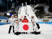 　女子個人ノーマルヒルで銅メダルを獲得し、チームスタッフらと喜ぶ丸山希（右から３人目）＝プレダッツォ（共同）