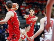 　デンソー―富士通　第１クオーター、パスを出す富士通・町田（奥）＝代々木第二体育館