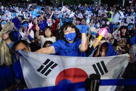 　出口調査の結果を受け、喜ぶ「共に民主党」の李在明前代表の支持者ら＝３日夜、ソウル（共同）