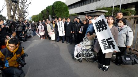 　脱北者ら４人が北朝鮮政府に損害賠償を求めた訴訟の差し戻し審判決で勝訴し、写真に納まる原告ら＝２６日午後、東京地裁