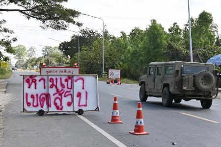 　タイ・シーサケート県ガンタララの検問所に掲げられた看板。「進入禁止、衝突地帯」と書かれている＝昨年１２月