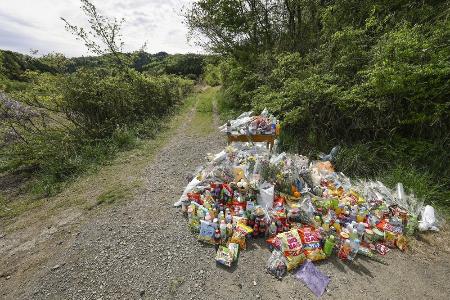 　遺体が遺棄された現場付近に供えられた花や飲み物など＝４月２２日、京都府南丹市