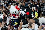 　日本のナショナルデーで、大屋根リングの下をパレードするハローキティとくまモン＝３日午後、大阪市此花区の夢洲